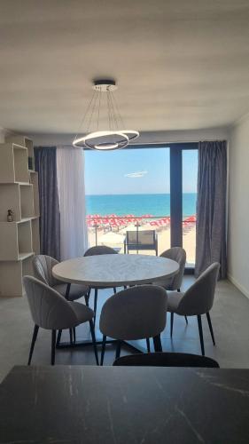 a dining room with a table and chairs and the beach at Aqua Villa by the Sea in Eforie Sud