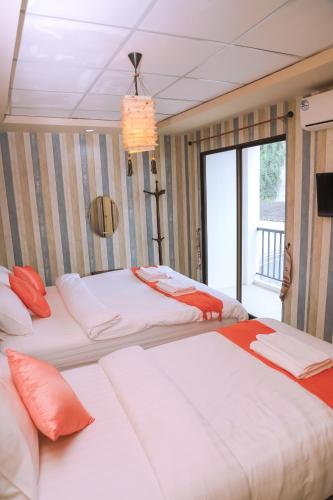 a bedroom with two beds and a large window at TC House and Cafe in Chiang Mai