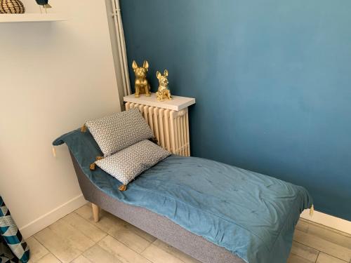 Cette chambre dispose d'un lit avec un mur bleu. dans l'établissement La Grande Terrasse, appartement rez-de-jardin, à Caen