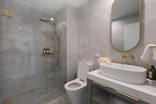 a bathroom with a toilet and a sink and a shower at 'Vinyl' 1-BR Apt in the heart of Burwood with study n free parking in Sydney