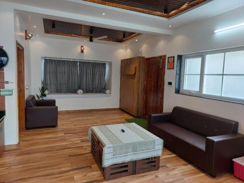 チクマガルールにあるShaiva Urban Retreatのソファとテーブルのあるリビングルーム