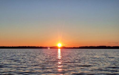 a sunset over a large body of water at Fish and sleep - lake house in Alūksne