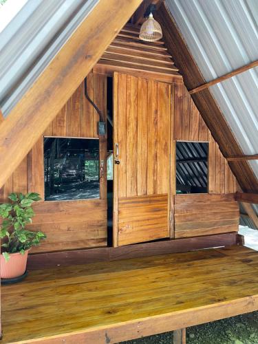 a wooden dog house with a pitched roof at Khao Phang Camping in Ban Pha Saeng Lang