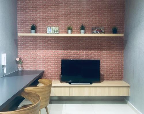 a television sitting on a counter next to a brick wall at Vintage Homes at i-City - WiFi TV Box 1 Carpark in Shah Alam
