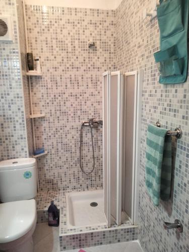 a bathroom with a shower with a toilet and a sink at Bouchra in Martil