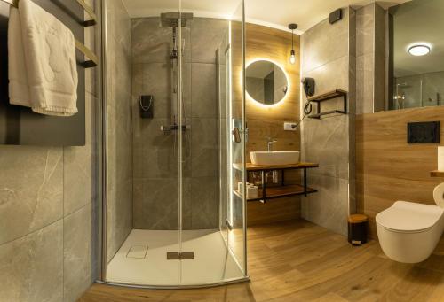 a bathroom with a shower with a toilet and a sink at Villa Park Zwierzyniec in Zwierzyniec