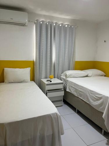 a bedroom with two beds and a window at Casa com piscina em Carapibus - Jacumã in Conde
