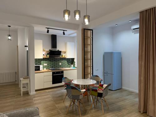a kitchen and dining room with a table and chairs at Lovely and cozy apartment! in Kutaisi