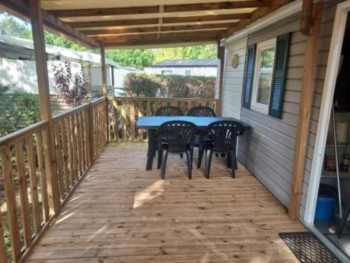 un patio avec une table et des chaises sur une terrasse dans l'établissement Mobil-home 4-6 personnes, à Aureilhan