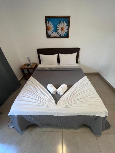 a bedroom with a large bed with two pillows on it at Pousada Capitólio in Capitólio