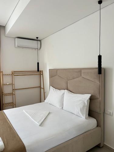 a bed with white sheets and pillows in a room at Inscape Apartments in Sarandë