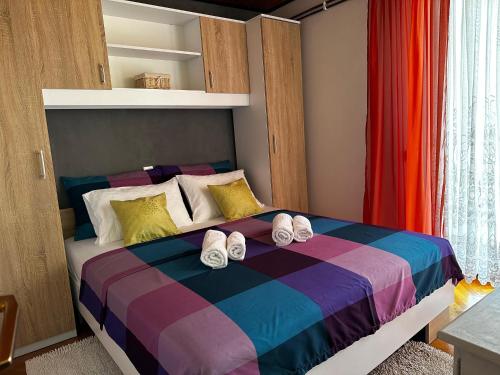 a bedroom with a bed with slippers on it at Apartman Petrić in Rijeka