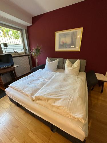 a bedroom with a large bed with white sheets and pillows at Ferienwohnung Zum Fiaker in Garmisch-Partenkirchen