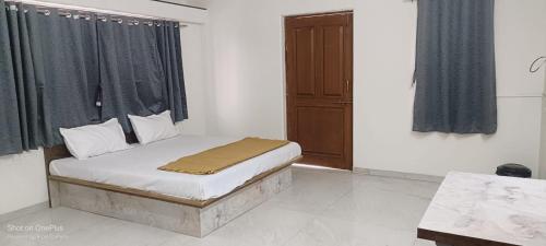 a small bed in a room with a window at Tulsi Bliss The Holiday Home in Nashik
