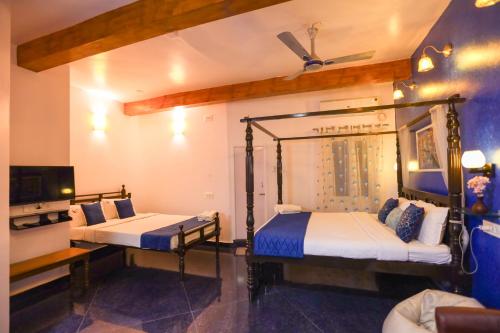 a room with two beds and a tv at Le Clarisse Guest House in Puducherry