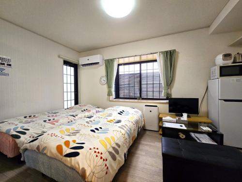 熊本市にあるComfort CUBE PHOENIX S Kumamotoのベッドとテレビのある寝室