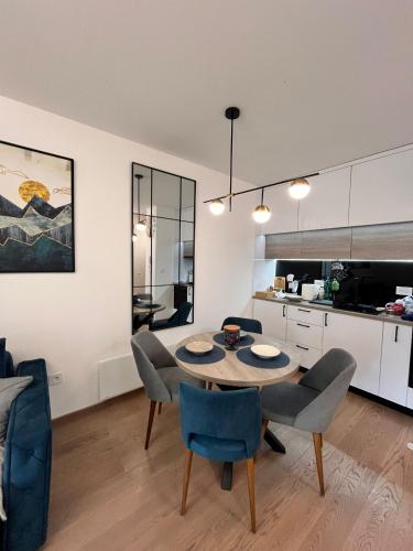 une cuisine et une salle à manger avec une table et des chaises dans l'établissement Apartman Bojic, à Palisat