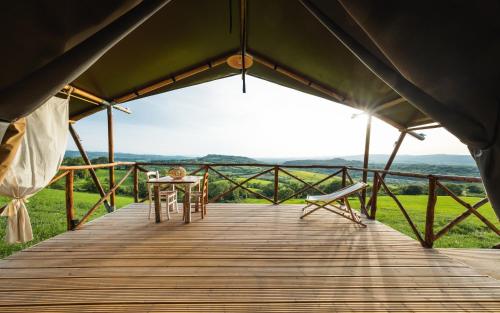 a wooden deck with a table and a chair at TERRA - Saturnia tented lodges in Saturnia