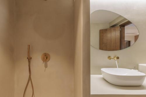 a bathroom with a white sink and a mirror at Aurora Skopelos in Skopelos Town