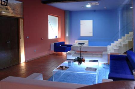 a living room with blue walls and white furniture at La Merced de la Concordia in Tarazona de Aragón