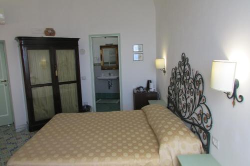 a bedroom with a bed and a bathroom with a sink at Domus Claudia in Atrani