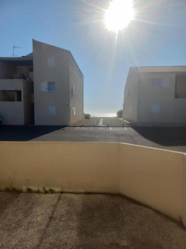 una vista di due edifici con il sole nel cielo di T1 bord de mer a Châtelaillon-Plage