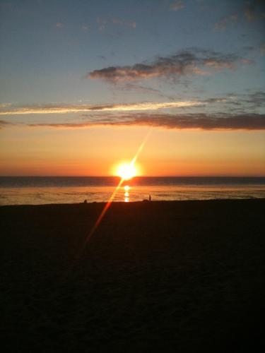 un tramonto sulla spiaggia con il sole che tramonta di T1 bord de mer a Châtelaillon-Plage