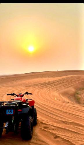 a red and black atv on the sand in the desert at Sahara Elegance Camp in Merzouga