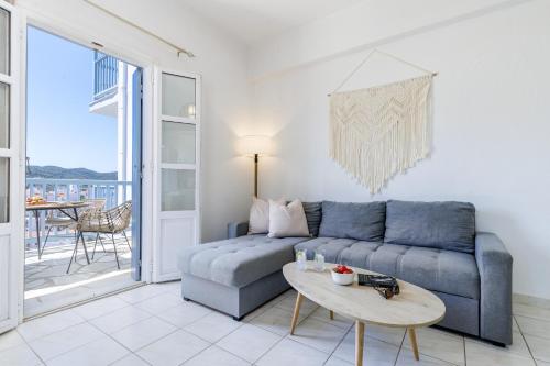 a living room with a blue couch and a table at Aurora Skopelos in Skopelos Town