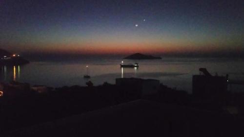 a view of the ocean at night with a boat in the water at Aegean Balconies in Vromolithos Beach, Leros in Vromolithos