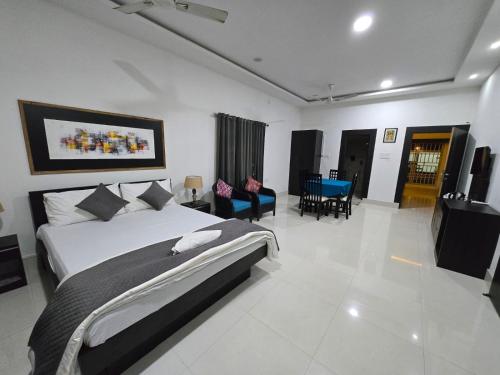 a bedroom with a large bed and a living room at The Meeras Retreat in Jorhat