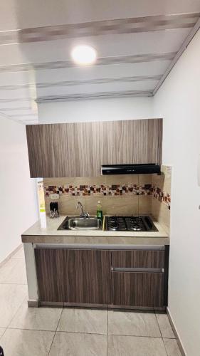 a kitchen with a sink and a stove at Apartamento moderno con balcón - Pitalito Huila in Pitalito