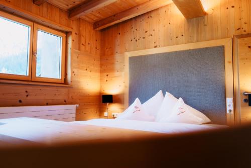 a bedroom with a bed with white pillows at Pension Rudolph in Gaschurn
