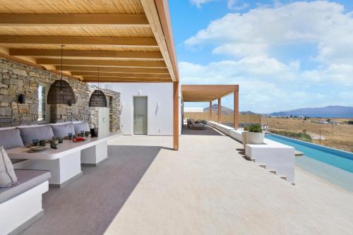 an outdoor patio with white furniture and a swimming pool at Asana 1 in Márpissa