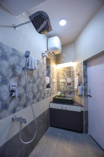 a bathroom with a shower and a sink and a mirror at Le Clarisse Guest House in Puducherry