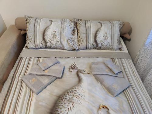 a bed with two pillows and towels on it at Coin paradisien à 10 MINUTES de paris in Meudon