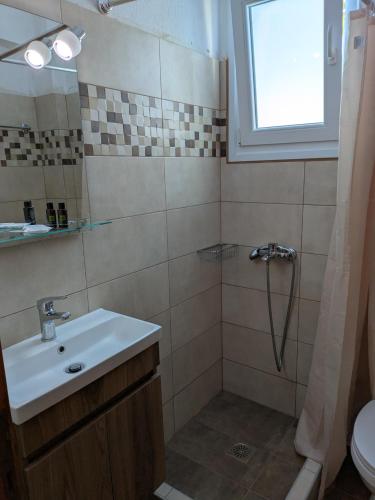 a bathroom with a sink and a shower at Guesthouse Christos in Skopelos Town