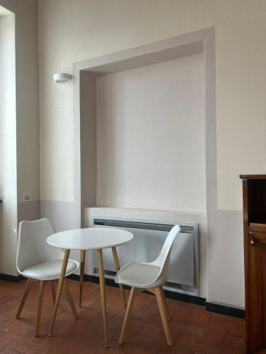 a table and two white chairs in a room at Albergo Palazzo Costa in Beverino