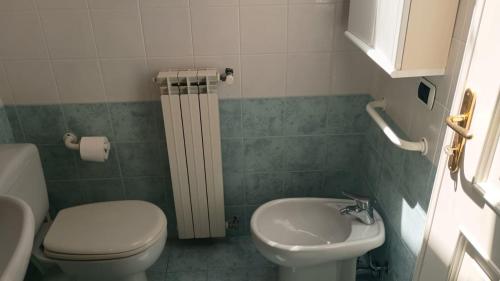 a small bathroom with a toilet and a sink at Fratti Central Beach Rooms in Viareggio