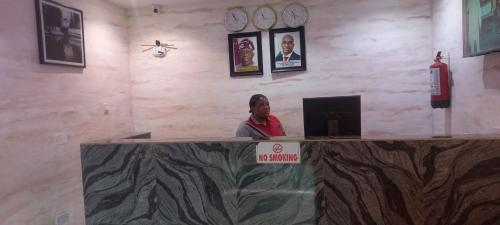 Eine Frau, die an einem Tresen in einer Bar sitzt. in der Unterkunft Estad hotel in Benin-Stadt