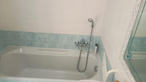 a bath tub with a shower in a bathroom at Fratti Central Beach Rooms in Viareggio