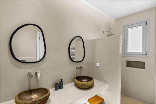 a bathroom with a sink and mirrors on the wall at Asana 1 in Márpissa
