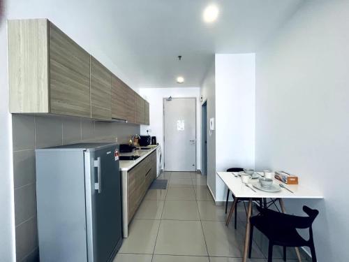 a small kitchen with a table and a refrigerator at Dino Homes at i-City - WiFi TV Box 1 Carpark in Shah Alam