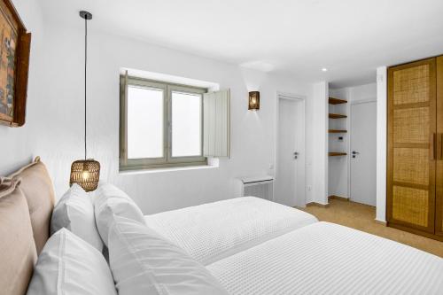 a white bedroom with a bed and a window at Asana 1 in Márpissa