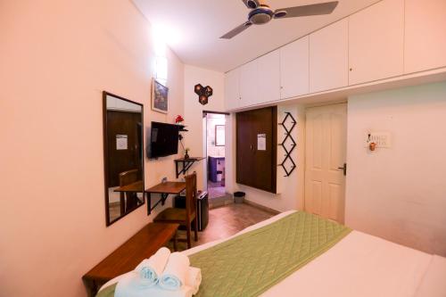 a bedroom with a bed and a desk in it at Le Clarisse Guest House in Puducherry
