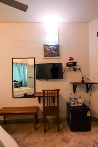 a room with a mirror and a chair at Le Clarisse Guest House in Puducherry