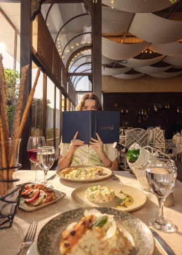 a woman is sitting at a table reading a book at Sonesta Hotel Tower & Casino Cairo in Cairo