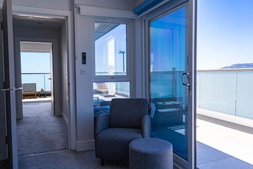 a living room with a chair and a balcony at Wight Stone Luxury Townhouse - Breathtaking Views in Sandown