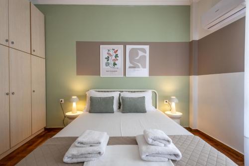 a bedroom with a white bed with two towels at Meros - Athenian Residencies in Athens