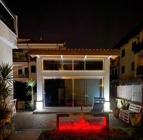 a house with a red fountain in front of it at night at Suite House in Sora